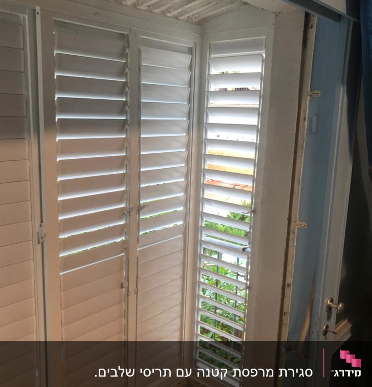 תריסי אלומיניום לבנים בחלון פינת חדר